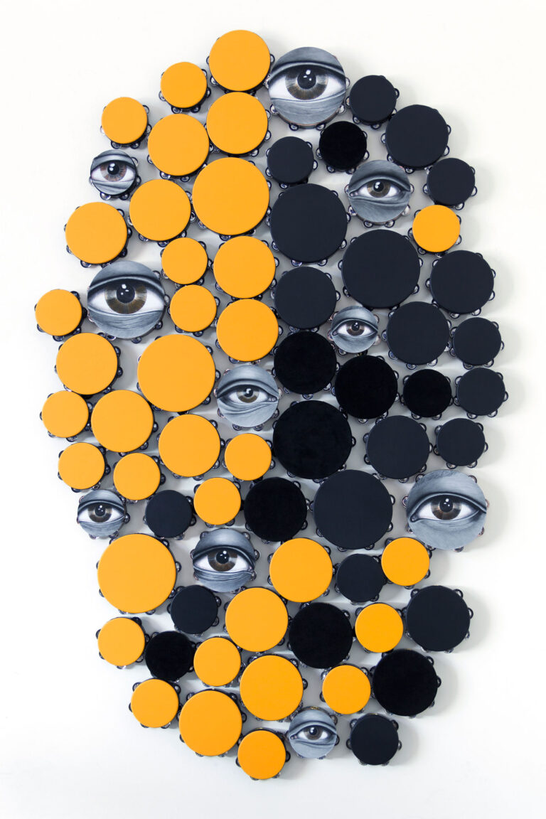 Installation of tambourines in black and yellow with eyes, by Lava Thomas