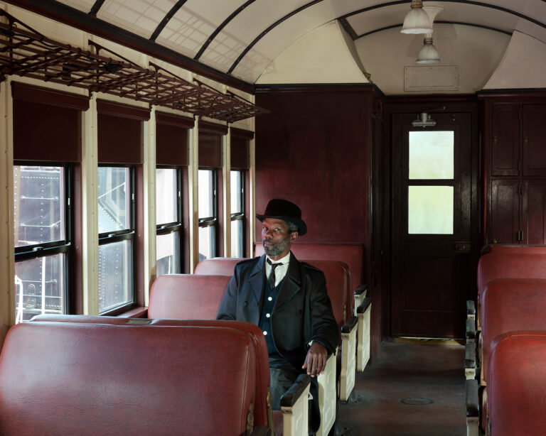 Self portrait in period dress on an empty train, by Jonathan Calm